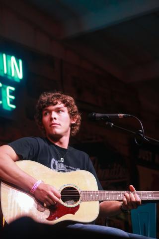 Man playing guitar in front of a microphone