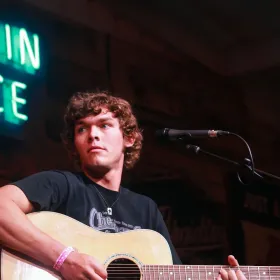 Man playing guitar in front of a microphone