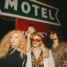 band in front of motel sign