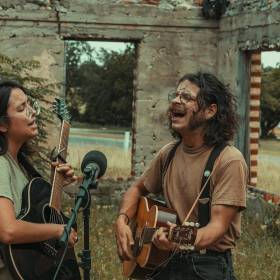 two humans with guitars