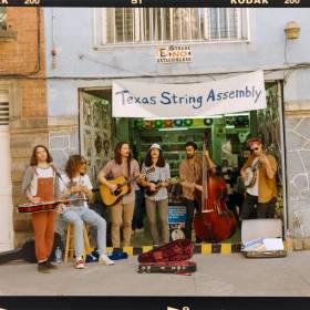 photo of full band each holding stringed instrument
