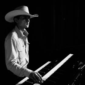 Man with cowboy hat and keyboard