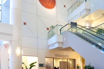 image of the lobby of the Student Services Building with the UT Austin seal above a set of escalators  
