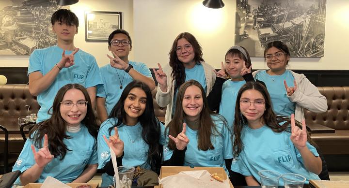 9 students with the hook 'em sign 