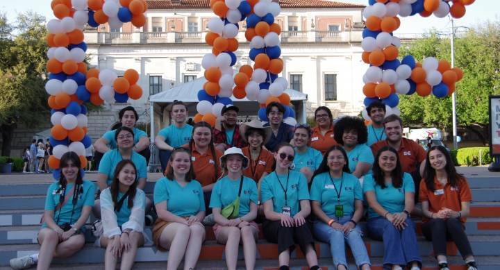 students posed in front of balloons