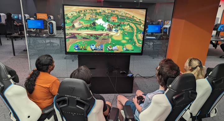 Four students sitting around a TV playing on the Nintendo Switch