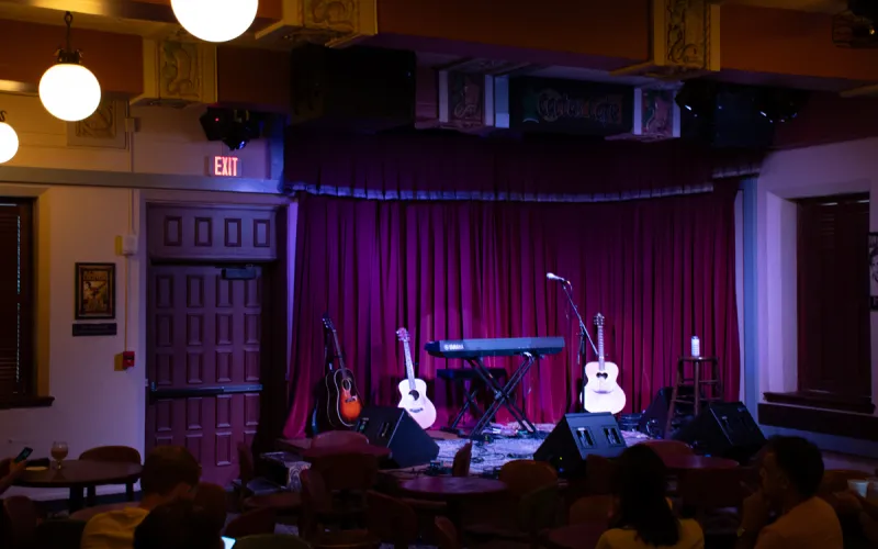 An image of the Cactus Cafe with no audience or performers, but with two gutairs on stands